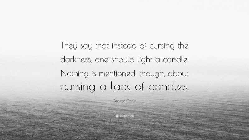 George Carlin Quote: “They say that instead of cursing the darkness, one should light a candle. Nothing is mentioned, though, about cursing a lack of candles.”