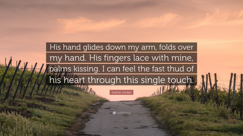 Sophie Jordan Quote: “His hand glides down my arm, folds over my hand. His fingers lace with mine, palms kissing. I can feel the fast thud of his heart through this single touch.”