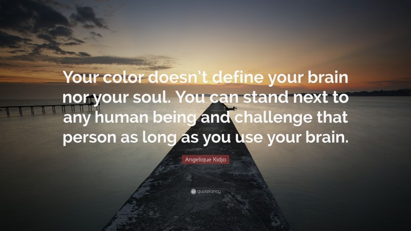 Angelique Kidjo Quote: “Your color doesn’t define your brain nor your soul. You can stand next to any human being and challenge that person as long as you use your brain.”