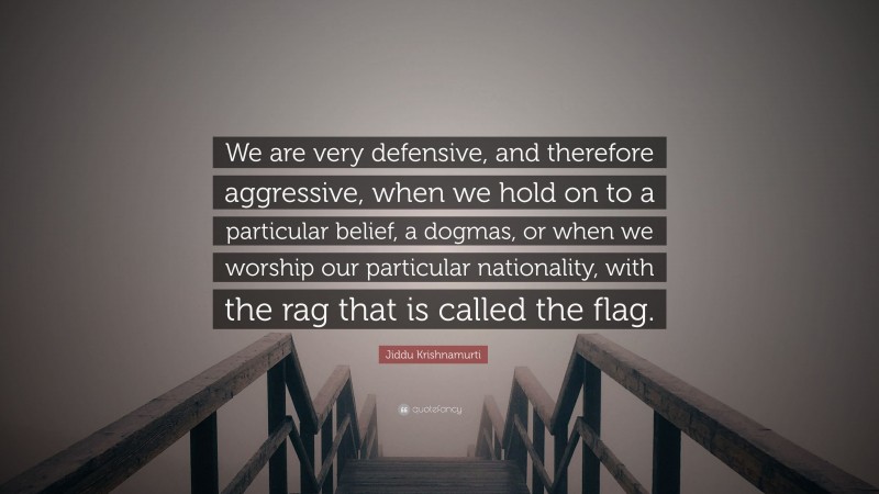 Jiddu Krishnamurti Quote: “We are very defensive, and therefore aggressive, when we hold on to a particular belief, a dogmas, or when we worship our particular nationality, with the rag that is called the flag.”