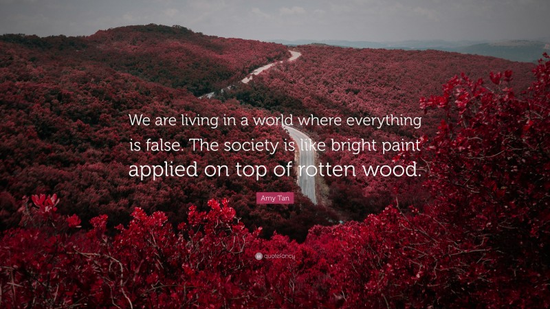 Amy Tan Quote: “We are living in a world where everything is false. The society is like bright paint applied on top of rotten wood.”