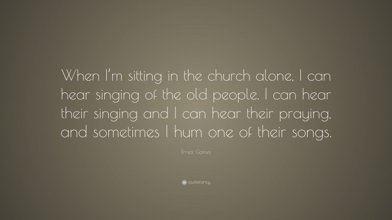 Ernest Gaines Quote: “When I’m sitting in the church alone, I can hear singing of the old people. I can hear their singing and I can hear their praying, and sometimes I hum one of their songs.”