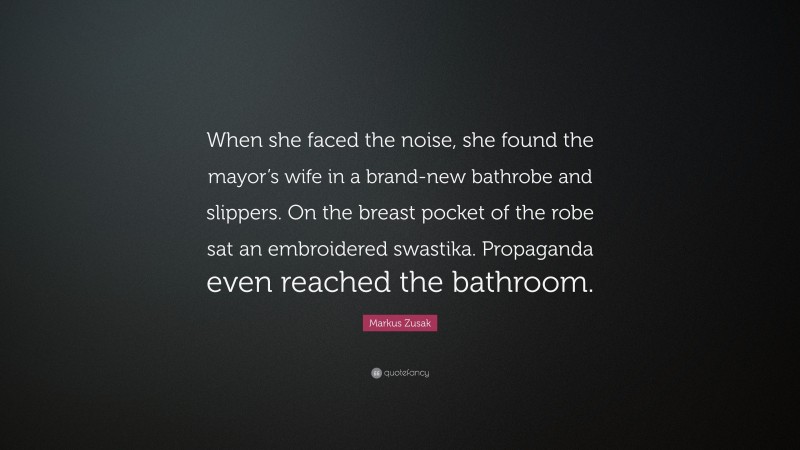Markus Zusak Quote: “When she faced the noise, she found the mayor’s wife in a brand-new bathrobe and slippers. On the breast pocket of the robe sat an embroidered swastika. Propaganda even reached the bathroom.”