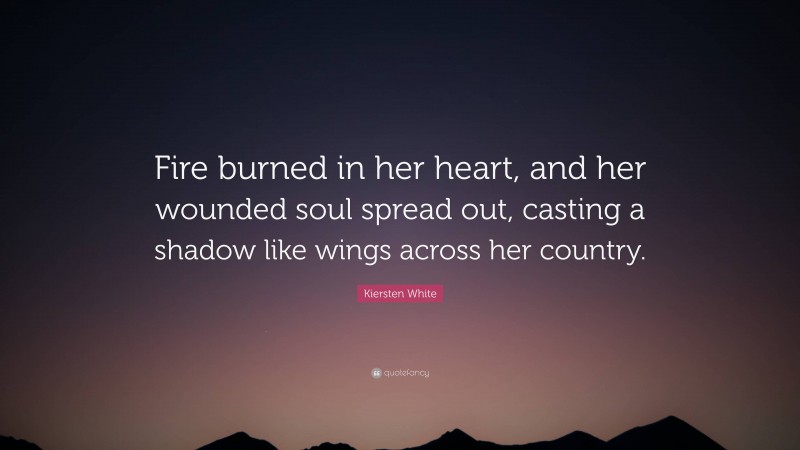 Kiersten White Quote: “Fire burned in her heart, and her wounded soul spread out, casting a shadow like wings across her country.”