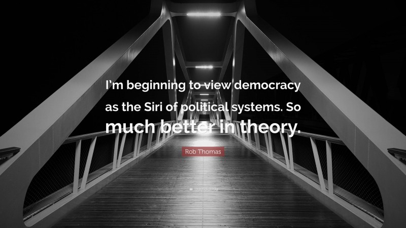 Rob Thomas Quote: “I’m beginning to view democracy as the Siri of political systems. So much better in theory.”