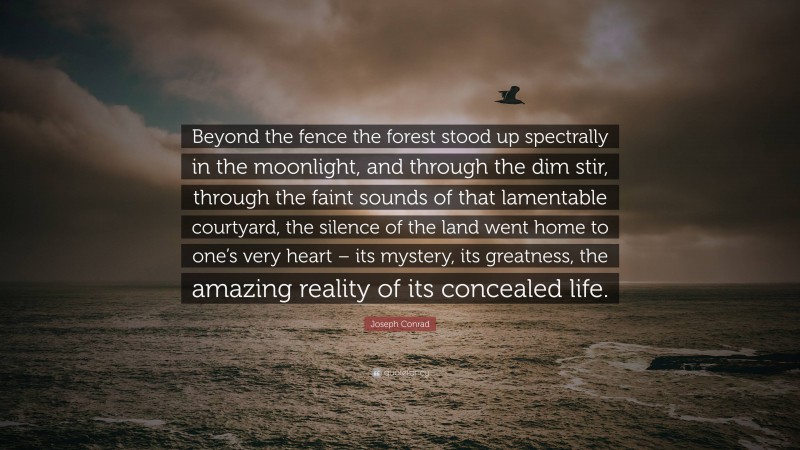 Joseph Conrad Quote: “Beyond the fence the forest stood up spectrally in the moonlight, and through the dim stir, through the faint sounds of that lamentable courtyard, the silence of the land went home to one’s very heart – its mystery, its greatness, the amazing reality of its concealed life.”