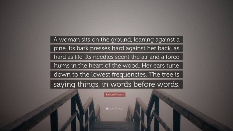 Richard Powers Quote: “A woman sits on the ground, leaning against a pine. Its bark presses hard against her back, as hard as life. Its needles scent the air and a force hums in the heart of the wood. Her ears tune down to the lowest frequencies. The tree is saying things, in words before words.”
