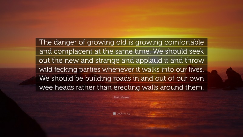 Kevin Hearne Quote: “The danger of growing old is growing comfortable and complacent at the same time. We should seek out the new and strange and applaud it and throw wild fecking parties whenever it walks into our lives. We should be building roads in and out of our own wee heads rather than erecting walls around them.”