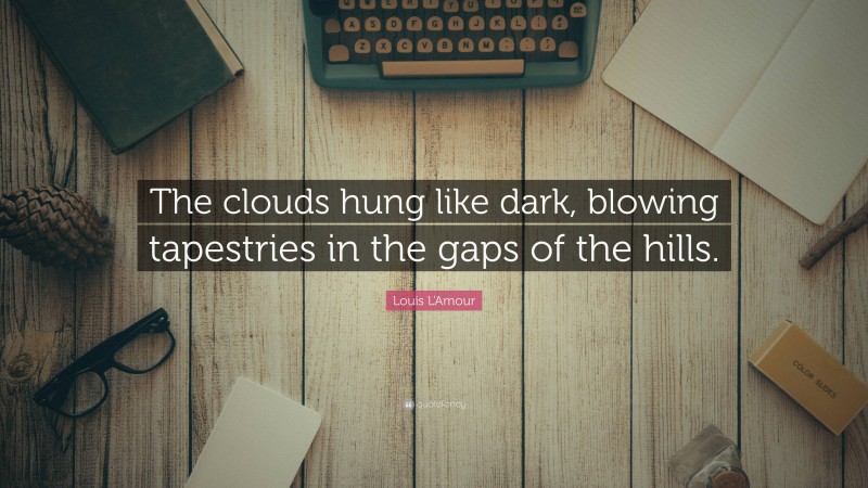 Louis L'Amour Quote: “The clouds hung like dark, blowing tapestries in the gaps of the hills.”