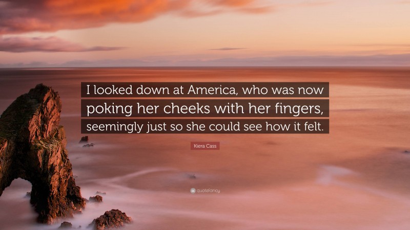 Kiera Cass Quote: “I looked down at America, who was now poking her cheeks with her fingers, seemingly just so she could see how it felt.”