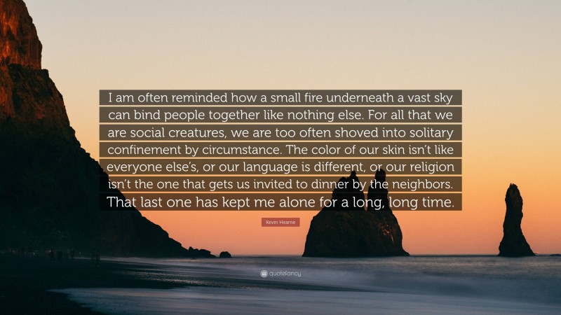 Kevin Hearne Quote: “I am often reminded how a small fire underneath a vast sky can bind people together like nothing else. For all that we are social creatures, we are too often shoved into solitary confinement by circumstance. The color of our skin isn’t like everyone else’s, or our language is different, or our religion isn’t the one that gets us invited to dinner by the neighbors. That last one has kept me alone for a long, long time.”