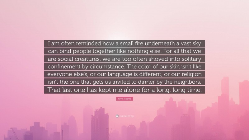 Kevin Hearne Quote: “I am often reminded how a small fire underneath a vast sky can bind people together like nothing else. For all that we are social creatures, we are too often shoved into solitary confinement by circumstance. The color of our skin isn’t like everyone else’s, or our language is different, or our religion isn’t the one that gets us invited to dinner by the neighbors. That last one has kept me alone for a long, long time.”