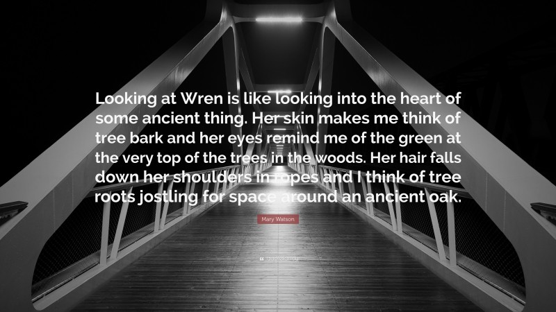 Mary Watson Quote: “Looking at Wren is like looking into the heart of some ancient thing. Her skin makes me think of tree bark and her eyes remind me of the green at the very top of the trees in the woods. Her hair falls down her shoulders in ropes and I think of tree roots jostling for space around an ancient oak.”