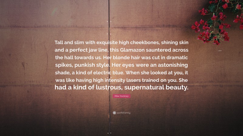 Mike Hockney Quote: “Tall and slim with exquisite high cheekbones, shining skin and a perfect jaw line, this Glamazon sauntered across the hall towards us. Her blonde hair was cut in dramatic spikes, punkish style. Her eyes were an astonishing shade, a kind of electric blue. When she looked at you, it was like having high intensity lasers trained on you. She had a kind of lustrous, supernatural beauty.”