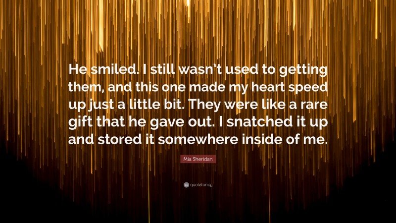 Mia Sheridan Quote: “He smiled. I still wasn’t used to getting them, and this one made my heart speed up just a little bit. They were like a rare gift that he gave out. I snatched it up and stored it somewhere inside of me.”