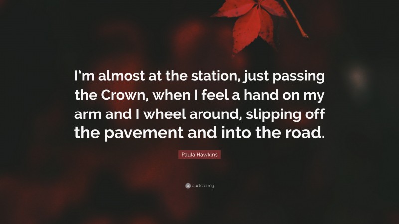 Paula Hawkins Quote: “I’m almost at the station, just passing the Crown, when I feel a hand on my arm and I wheel around, slipping off the pavement and into the road.”