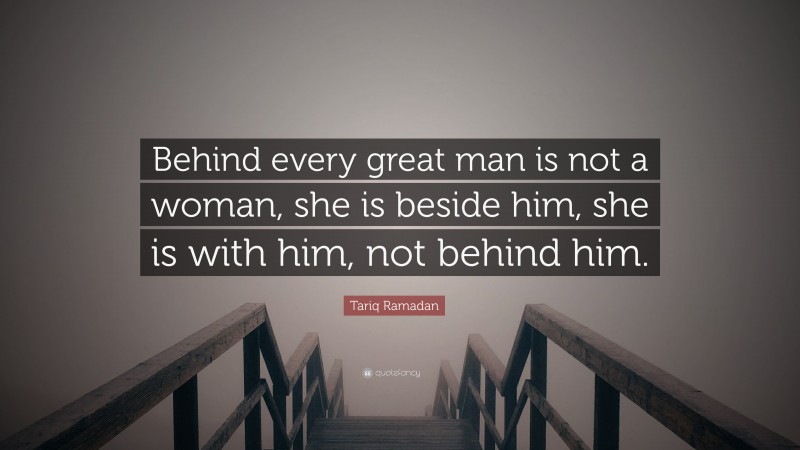 Tariq Ramadan Quote: “Behind every great man is not a woman, she is beside him, she is with him, not behind him.”