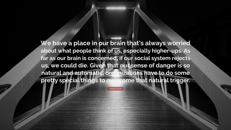 Daniel Coyle Quote: “We have a place in our brain that’s always worried about what people think of us, especially higher-ups. As far as our brain is concerned, if our social system rejects us, we could die. Given that our sense of danger is so natural and automatic, organizations have to do some pretty special things to overcome that natural trigger.”