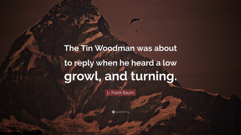 L. Frank Baum Quote: “The Tin Woodman was about to reply when he heard a low growl, and turning.”