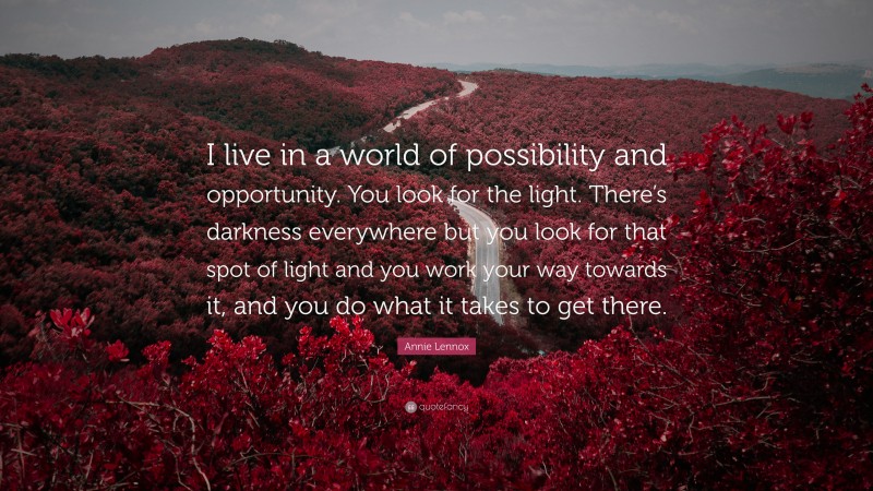 Annie Lennox Quote: “I live in a world of possibility and opportunity. You look for the light. There’s darkness everywhere but you look for that spot of light and you work your way towards it, and you do what it takes to get there.”