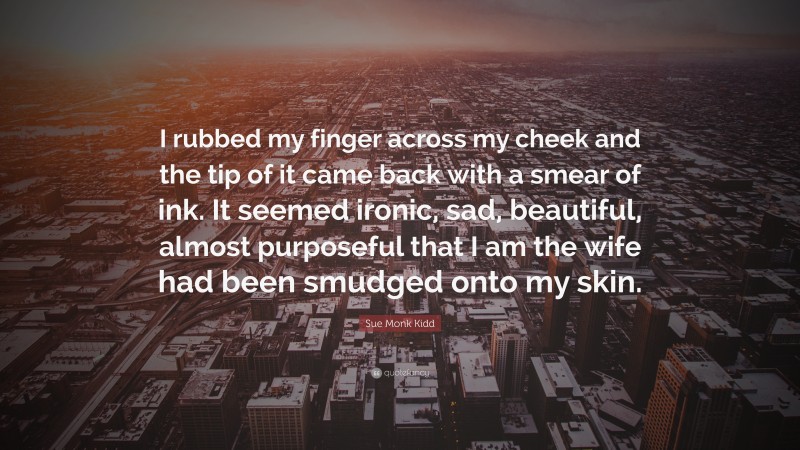 Sue Monk Kidd Quote: “I rubbed my finger across my cheek and the tip of it came back with a smear of ink. It seemed ironic, sad, beautiful, almost purposeful that I am the wife had been smudged onto my skin.”