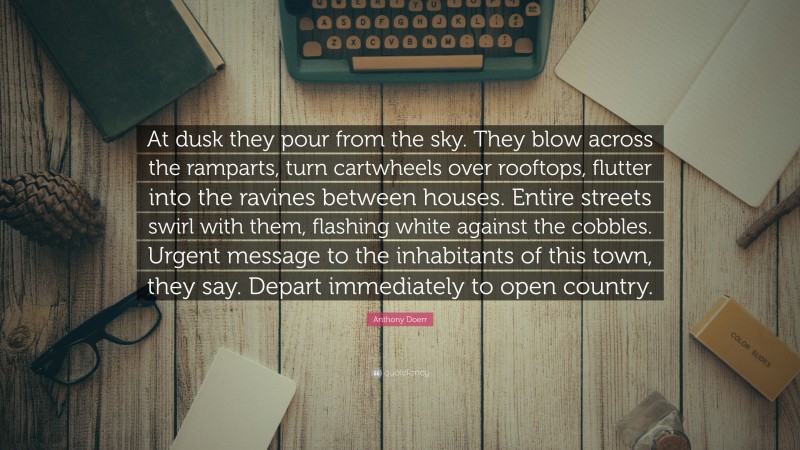 Anthony Doerr Quote: “At dusk they pour from the sky. They blow across the ramparts, turn cartwheels over rooftops, flutter into the ravines between houses. Entire streets swirl with them, flashing white against the cobbles. Urgent message to the inhabitants of this town, they say. Depart immediately to open country.”