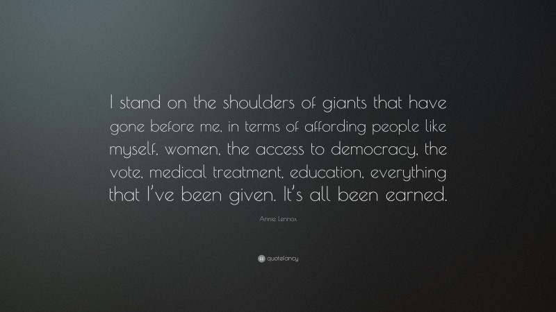 Annie Lennox Quote: “I stand on the shoulders of giants that have gone before me, in terms of affording people like myself, women, the access to democracy, the vote, medical treatment, education, everything that I’ve been given. It’s all been earned.”