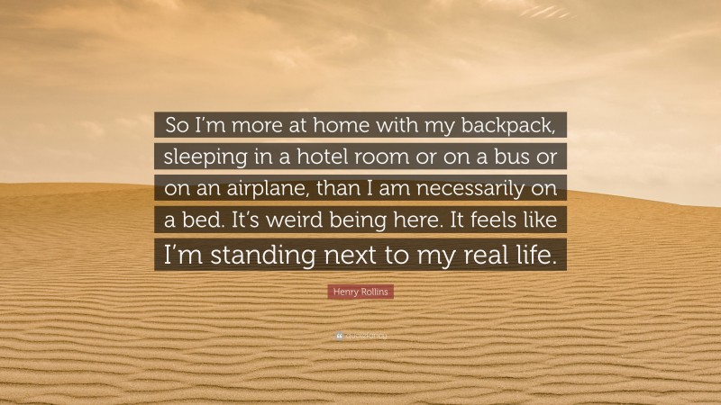Henry Rollins Quote: “So I’m more at home with my backpack, sleeping in a hotel room or on a bus or on an airplane, than I am necessarily on a bed. It’s weird being here. It feels like I’m standing next to my real life.”