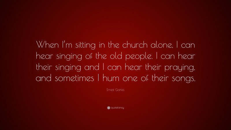 Ernest Gaines Quote: “When I’m sitting in the church alone, I can hear singing of the old people. I can hear their singing and I can hear their praying, and sometimes I hum one of their songs.”